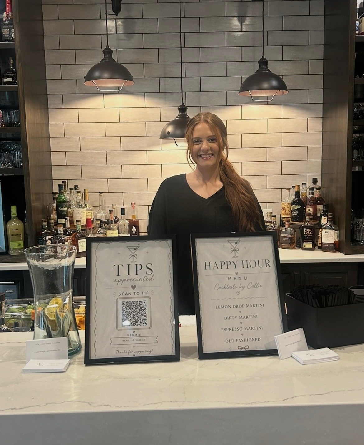 Callie behind the bar with the happy hour menu